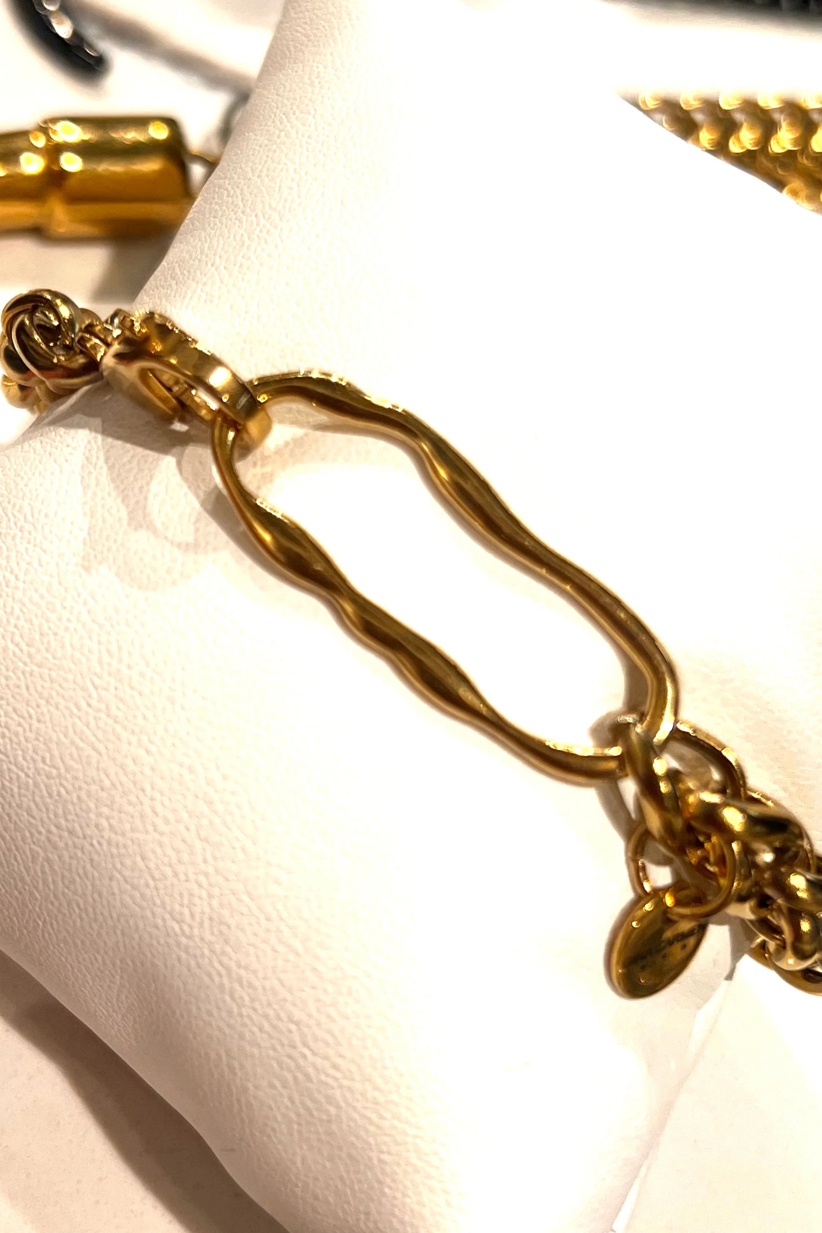 Gold bracelet with intricate design on a white surface